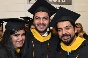 Three EP students wearing graduation gowns